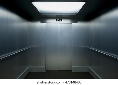 Interior view of a modern elevator with metallic walls.