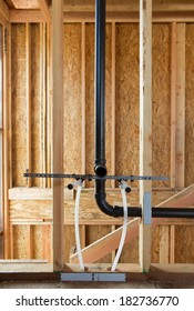 Interior View Of New Home Construction With Exposed Plumbing And Wood Studs. 