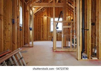 An Interior View Of A New Home Under Construction With Exposed Wiring And And A Ladder On The Floor. Horizontal Shot.