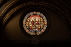 An Interior View Of An Old Church With A Stained Glass Window Of Religious Paintings