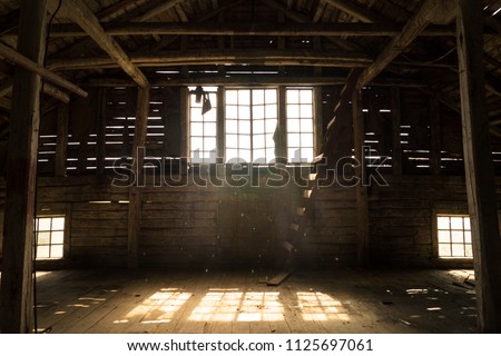 Interior view of the old village barn with old Windows and magical sunlight from it