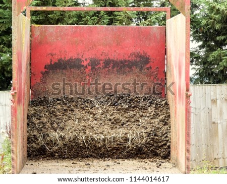 Interior view of an open topped trailer, partially loaded. Used for storing collected horse manure. When full it is recycled for compost or garden mulch. England. 