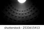 The interior view of the Pantheon dome in Rome, Italy, with coffered ceiling in black and white