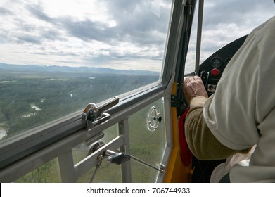 Interior View Of A Small Bush Plane With A Pilot And A Large Window With Landscape View Of Nature In Alaska