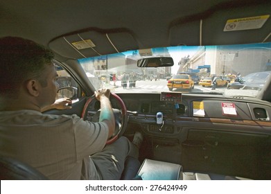 Interior View Of Taxi Cab And Driver Steering Through New York City, Manhattan Streets, New York