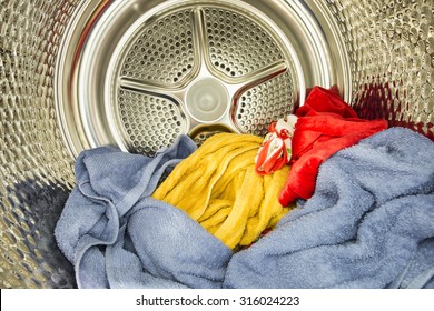 Interior View Of Tumble Dryer With Drying Clothes. Conceptual Image Of Housework And Doing Laundry.