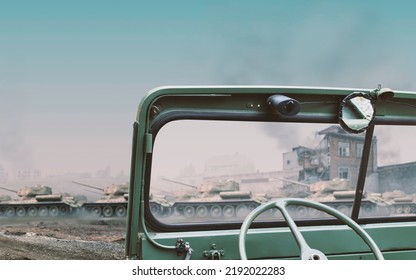 Interior Of A Vintage Green Convertible Military 4x4 SUV Car Dashboard With A War Scene Of Tanks And Burning Houses Visible Off Focus Through The Windshield With Copy Space