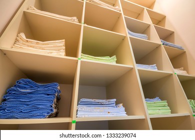 Interior Of White Plastic Cabinet Or Clothing Open Wardrobe With Stacked Piles Of Clean Colorful Linen On Shelves. Furniture Design, Hotel, Hospital Or Kindergarten Concept.