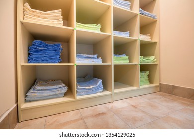 Interior Of White Plastic Cabinet Or Clothing Open Wardrobe With Stacked Piles Of Clean Colorful Linen On Shelves. Furniture Design, Hotel, Hospital Or Kindergarten Concept.