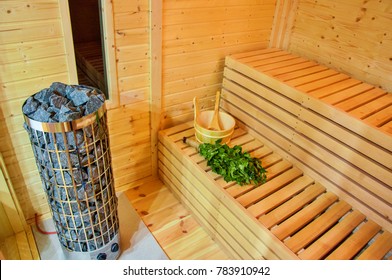 Interior Of Wooden Finnish Sauna With Birch Broom, Bucket And Stove. The Finnish Sauna Is A Substantial Part Of Their Culture.