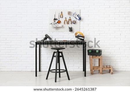 Interior of workshop with desk, peg board and working tools