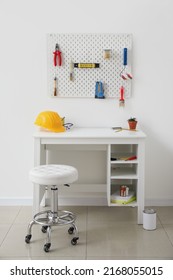 Interior Of Workshop With Desk And Pegboard On Light Wall