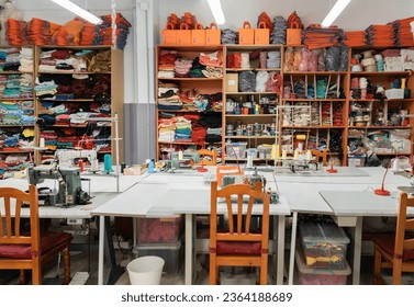 Interior of a workshop for sewing clothes and textiles. Without people. The workroom of seamstresses and dressmakers. Industrial scale.