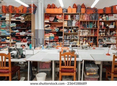 Interior of a workshop for sewing clothes and textiles. Without people. The workroom of seamstresses and dressmakers. Industrial scale.