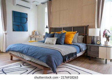 Interior Of Yellow And Blue Pillow On Cozy Modern Bedroom With Carpet And Side Table Lamp.