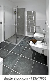 Interiors Shots Of A Modern Bathroom With Large Tiles Floor In Foreground The Bidet And Toilette Bowl In The Bottom The Glass Shower Box