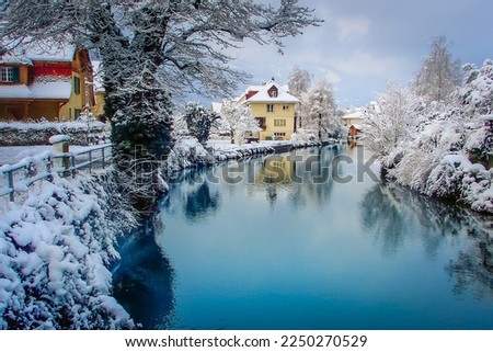 Interlaken idyllic landscape after snow in winter with river reflection, Swiss alps, Switzerland