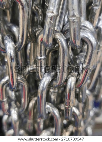 Interlinked silver metal chains in close-up view with reflective texture and oval links