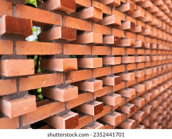 Interlocking bricks with gaps, creating a wall that allows airflow.