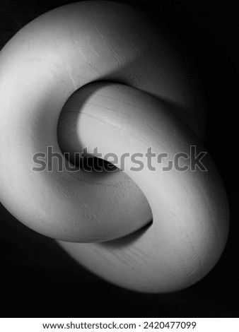 Interlocking rings, abstract circle shape and geometry for connection, closeness, linking, and relationships, a black and white background image