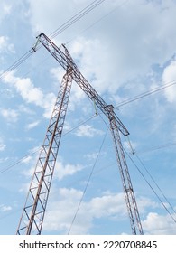 Intermediate steel high-voltage tower against a cloudy sky background. - Shutterstock ID 2220708845