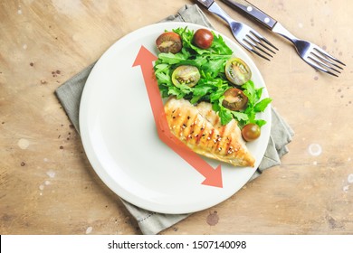 Intermittent fastin concept. One-third plate with healthy food and two-third plate is empty. Chicken fillet, arugula and tomatoes on a plate. Top view. Flat lay - Shutterstock ID 1507140098
