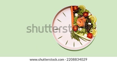 intermittent fasting concept clock dish with vegetables and salmon, fish, salad