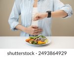 Intermittent fasting concept, Close-up on clock and people feeling hungry waiting time to eat during intermittent fasting diet session