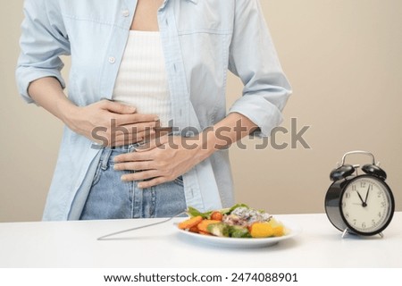 Intermittent fasting concept, Close-up on clock and people feeling hungry waiting time to eat during intermittent fasting diet session
