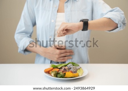 Intermittent fasting concept, Close-up on clock and people feeling hungry waiting time to eat during intermittent fasting diet session