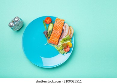 Intermittent fasting low carb hight fats diet concept flat lay, healthy food salmon fish, bacon meat, vegetables and salad on blue plate and clock alarm on blue background top view, space for text - Shutterstock ID 2109025511