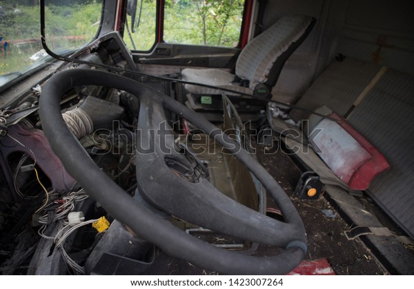 The internal of an\
abandoned truck with missing seats and other parts, at a car\
graveyard, Kozani, Greece.