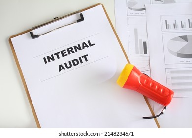 Internal audit paperwork documentations with torchlight, data and charts. Business improvement and quality management system concept.