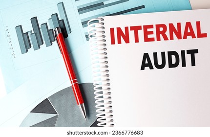 INTERNAL AUDIT text on notebook with pen on a chart background