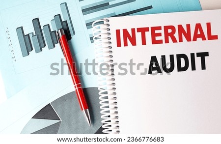 INTERNAL AUDIT text on notebook with pen on a chart background