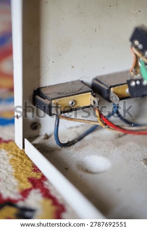 Internal electrical wiring and switch terminals inside a dirty metal casing of a stavolt stabilizer.