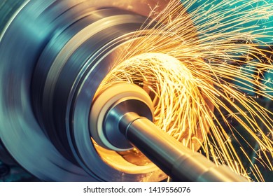 Internal grinding of a cylindrical part with an abrasive wheel on a machine, sparks fly in different directions. Metal machining.