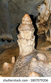 Internal images of caves, with geological formations of water dripping from the ceiling, forming stalactites and stalagmites formed on the floor. Geometric shapes and designs on the rock.