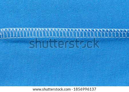 Internal machine seam on blue knitted material. Types of seams when sewing and cutting clothes