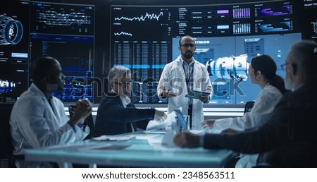 International Aerospace Research and Manufacturing Company Working on Turbine Jet Engine. Engineer Having a Meeting with a Group of Multiethnic Scientists in a Room with Big Digital Screen