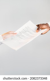 International Agreement. Global Export. Legal Deal. Closeup Of Diverse Business Partners Hands Holding Contract Document Isolated On Neutral Copy Space.