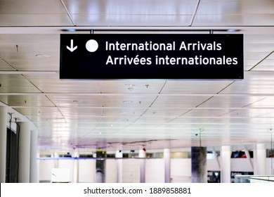 International Arrivals Sign Board In English And French At Airport Terminal Hall. Canada Government Fully Open Border For International Travellers Visitors Without Vaccine Passport.