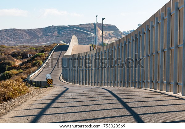 The international border\
wall between San Diego, California and Tijuana, Mexico, as it\
begins its journey from the Pacific coast and travels over nearby\
hills.  