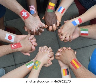 International brothers and sisters standing in a circle together and holding hands as a symbol for peace and the world community