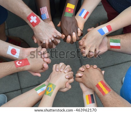 International brothers and sisters standing in a circle together and holding hands as a symbol for peace and the world community