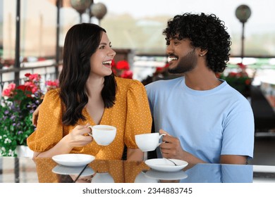 International dating. Happy couple enjoying tasty coffee in cafe - Powered by Shutterstock