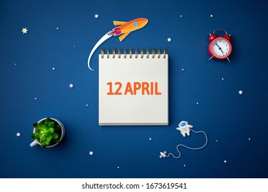 International day of human space flight. 12 April World Cosmonautics Day. Spiral notebook on abstract isolated blue background. Cartoon galactic concept.