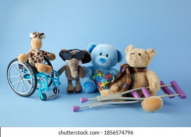 International Day Of Persons With Disabilities. Wheelchair With Toys Sign Of Different Disabilities On Blue Background.