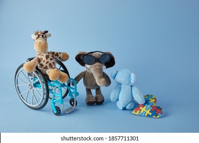 International Day Of Persons With Disabilities. Wheelchair With Toys Sign Of Different Disabilities On Blue Background.