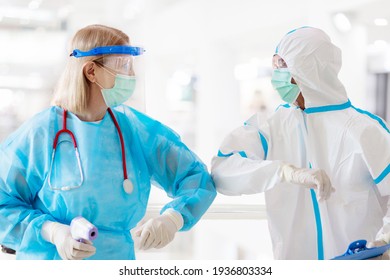 International Doctor Team. Hospital Medical Staff In Hazmat Suit, Face Shield And Mask. Mixed Race Asian And Caucasian Doctor And Nurse Meeting. Clinic Personnel With Stethoscope. Coronavirus Outbreak